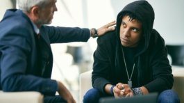 African American teenage boy having individual therapy session with mental health professional.