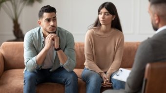 Couple talking at therapy session with professional male therapist