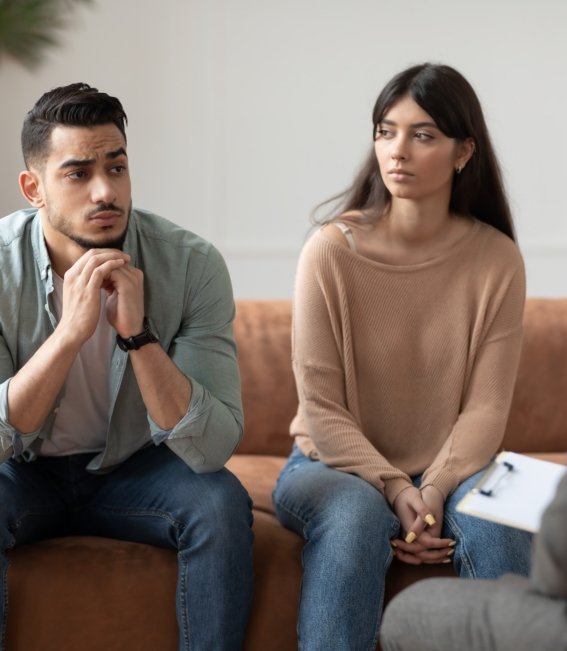 Couple talking at therapy session with professional male therapist