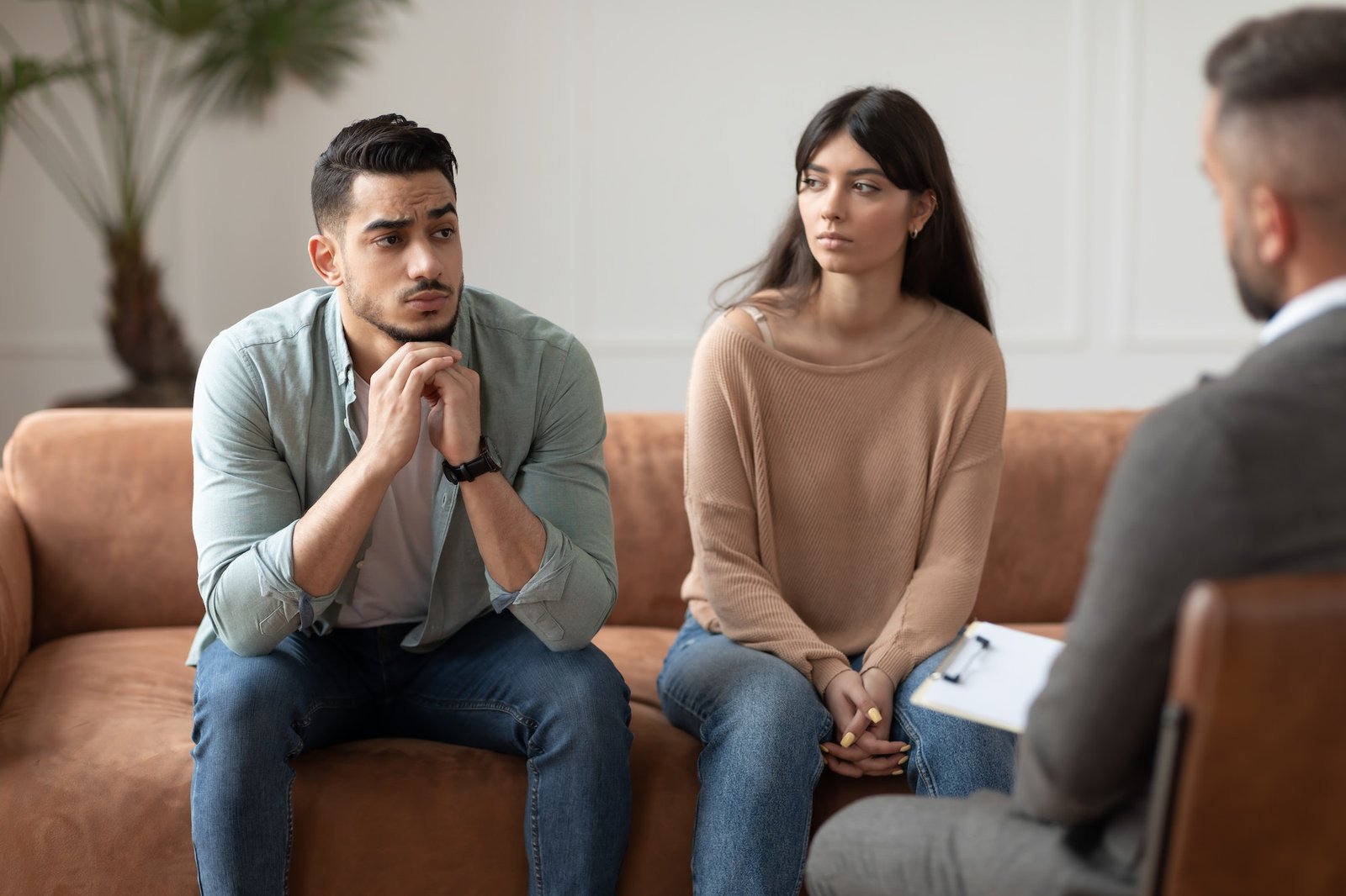 Couple talking at therapy session with professional male therapist