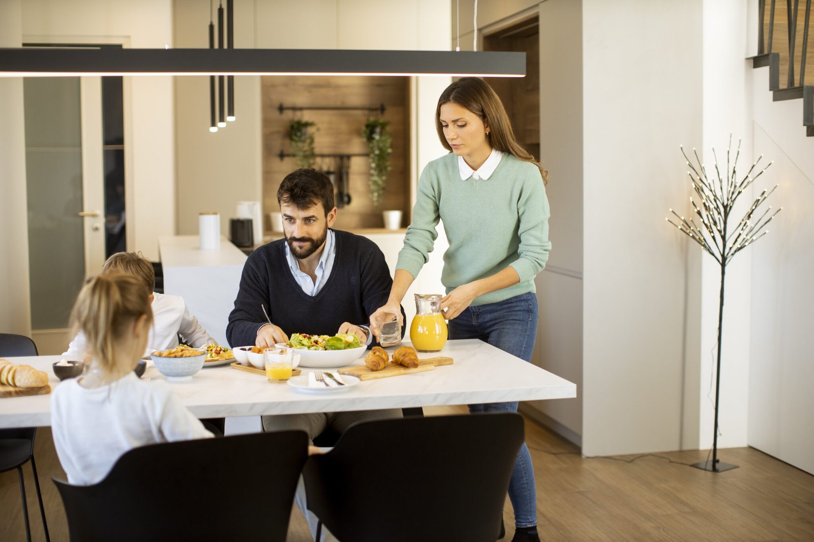 Young mother preparing breakfast for her family in the modern kitchen